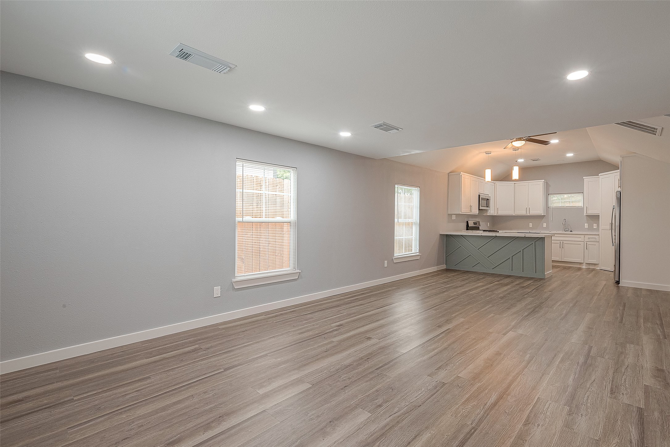 2725 Avenue F, Unit RR Rosenberg, TX 77471 - Photo 6 of 23 a view of an empty room with wooden floor and a kitchen