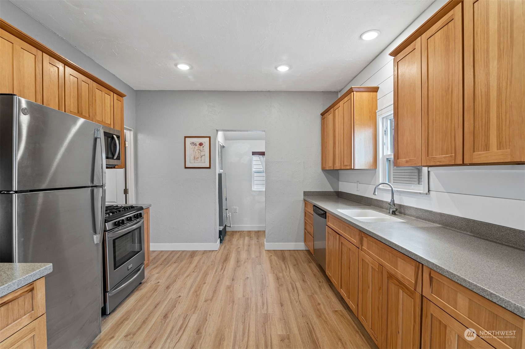 3015 21st Street Everett, WA 98201 - Photo 10 of 26 a kitchen with a refrigerator a sink and dishwasher with wooden floor