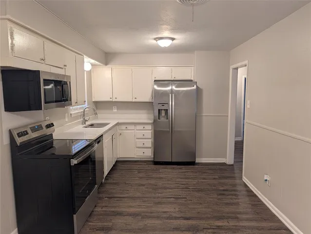 a kitchen with a refrigerator sink and wooden cabinets