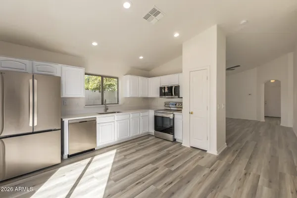 a kitchen with white cabinets and stainless steel appliances