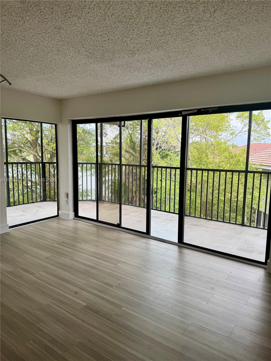 605 Ives Dairy Road, Unit 3067 Miami, FL 33179 - Photo 17 of 28 a view of empty room with wooden floor and floor to ceiling window
