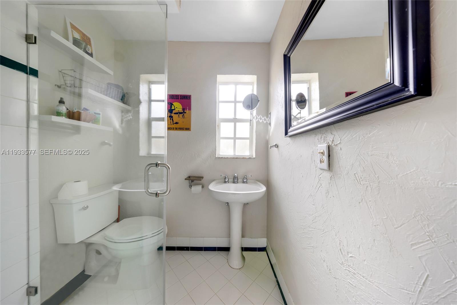 1840 Tigertail Avenue Miami, FL 33133 - Photo 11 of 32 a bathroom with a toilet sink and mirror