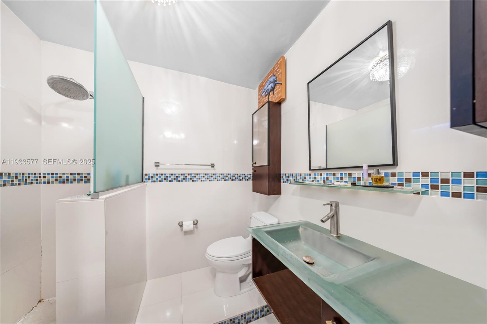 1840 Tigertail Avenue Miami, FL 33133 - Photo 25 of 32 a bathroom with a sink a toilet and a mirror