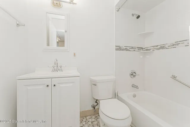 a bathroom with a toilet a sink a mirror and vanity