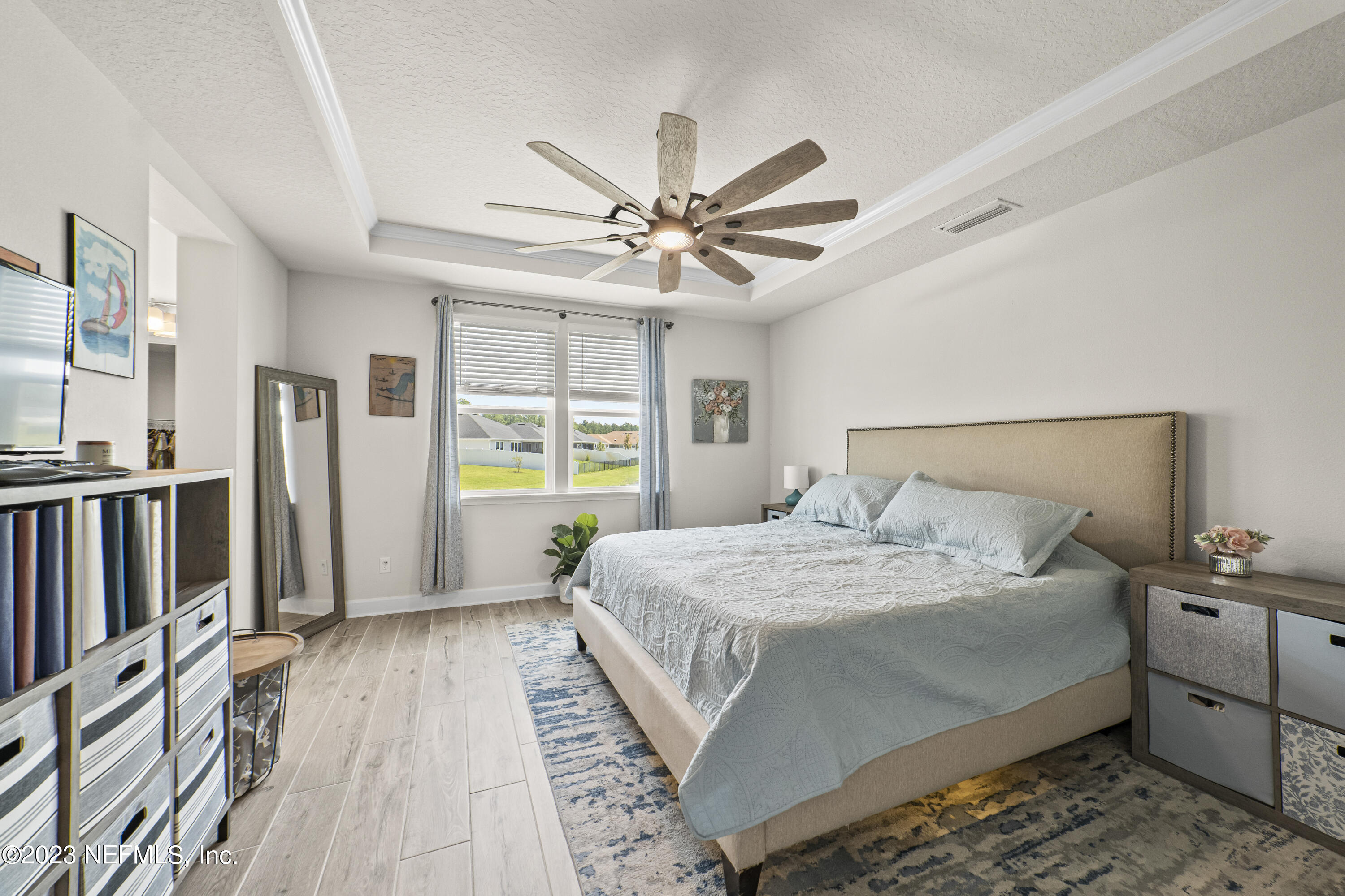 855 Flach Drive St. Johns, FL 32259 - Photo 22 of 50 a bedroom with a large bed a flat tv screen and a chandelier