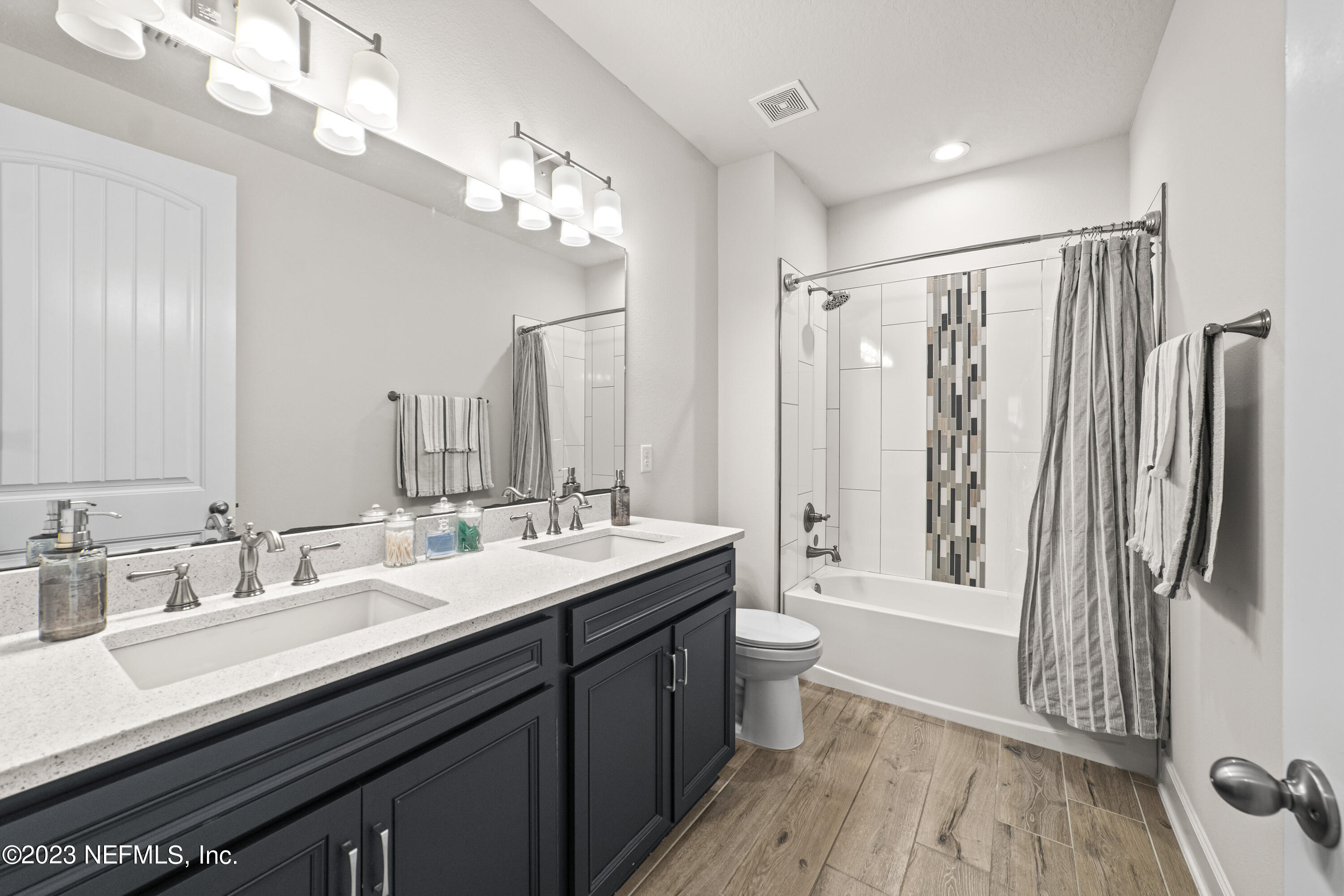 855 Flach Drive St. Johns, FL 32259 - Photo 38 of 50 a bathroom with double vanity sinks a toilet a mirror and shower