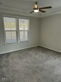 en empty room with windows and ceiling fan