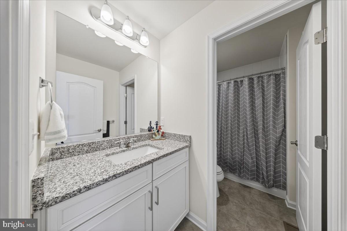 38023 Cross Gate Road Millville, DE 19967 - Photo 22 of 37 a bathroom with a granite countertop sink and a mirror