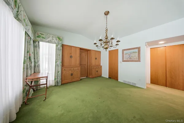 a view of empty room with windows and bathroom