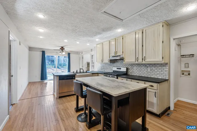 a kitchen with a table chairs sink and cabinets