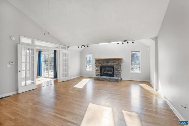 an empty room with wooden floor and fireplace