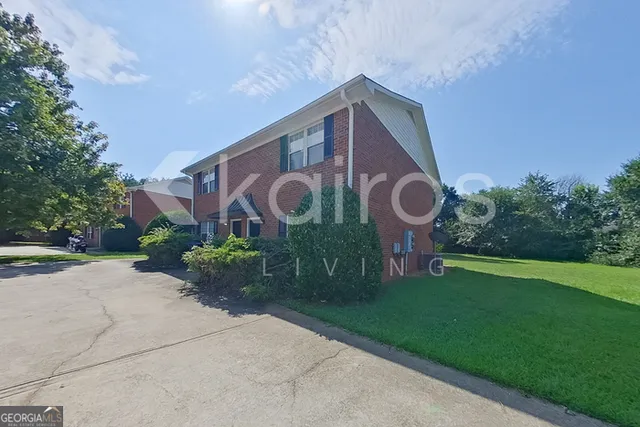 a view of a house with a yard and pathway