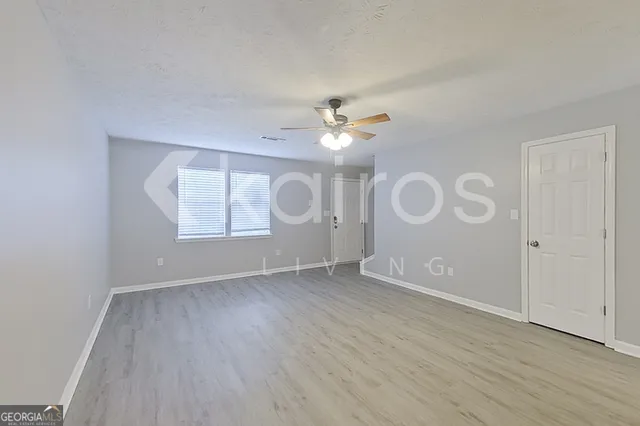 an empty room with wooden floor and window
