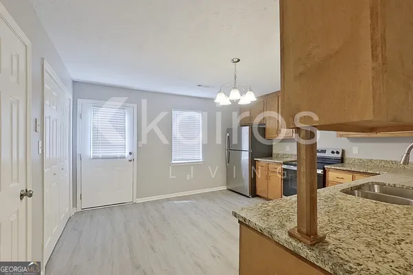 a kitchen with stainless steel appliances granite countertop a sink a oven and a refrigerator