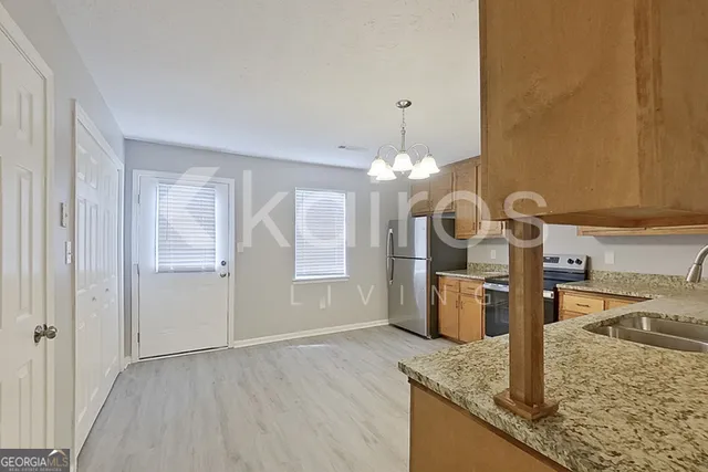 a kitchen with stainless steel appliances granite countertop a sink a oven and a refrigerator