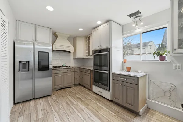 a kitchen with stainless steel appliances a sink cabinets and wooden floor