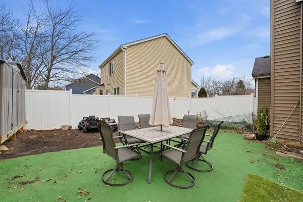 a backyard of a house with table and chairs