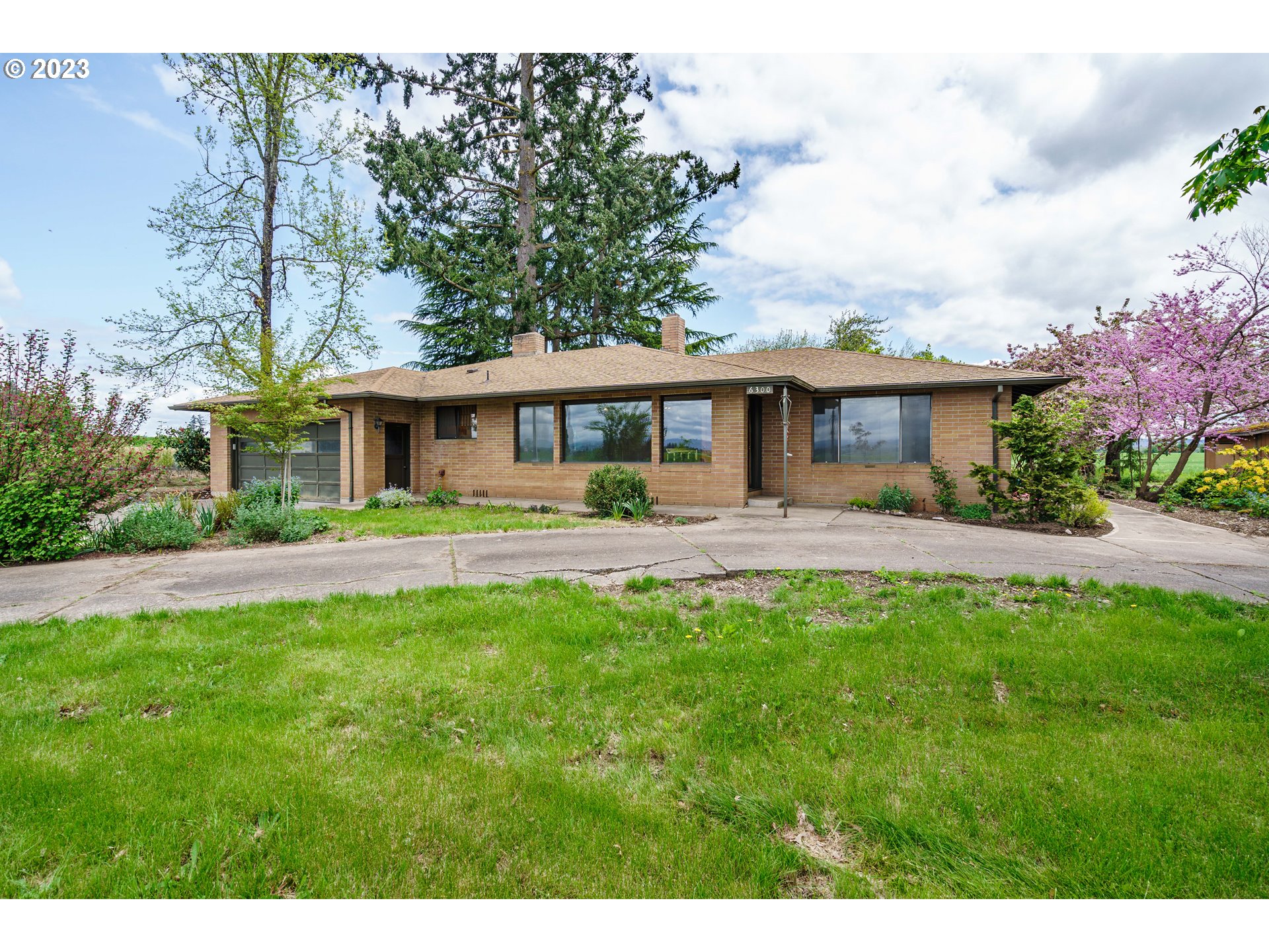 6300 Southwest Minter Bridge Road Hillsboro, OR 97123 - Photo 1 of 32 a front view of a house with swimming pool and garden