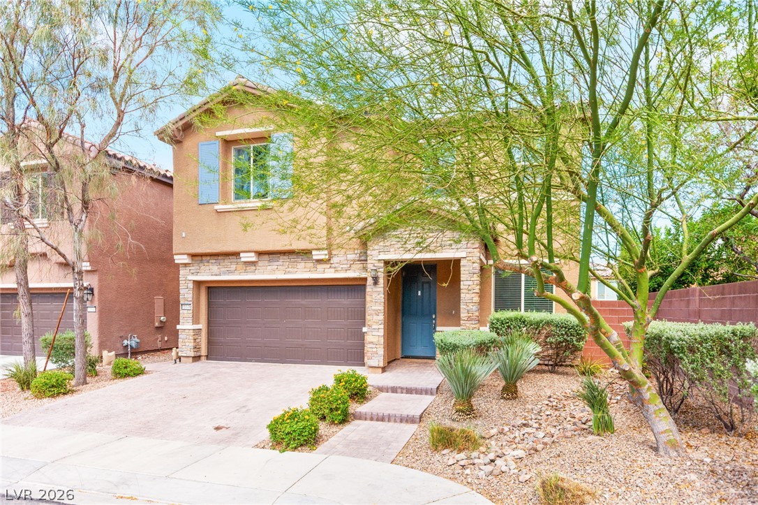 11048 Prairie Grove Road Las Vegas, NV 89179 - Photo 5 of 75 A charming stucco residence with stone accents offers a welcoming curb appeal and desert-friendly landscaping.