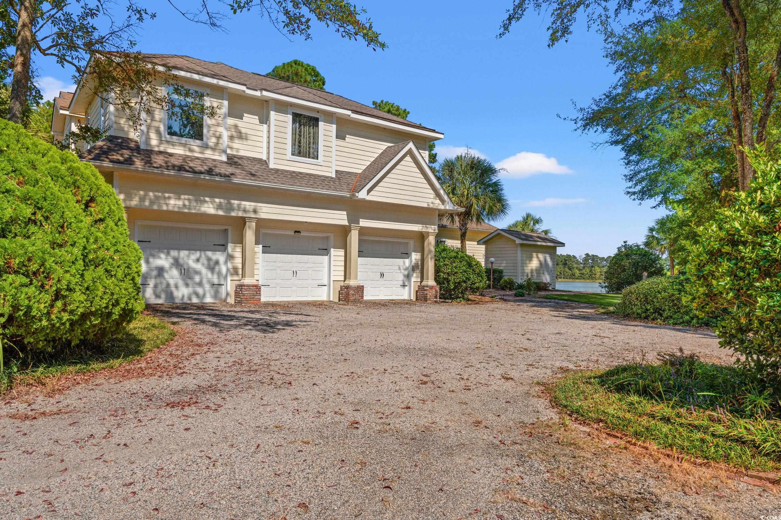 2790 Fowler Road Loris, SC 29569 - Photo 35 of 40 View of front of house with driveway, a garage, roof with shingles, and a water view