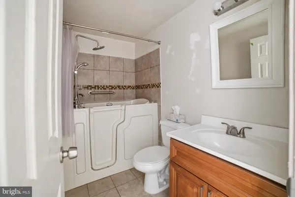 a bathroom with a granite countertop toilet sink and mirror