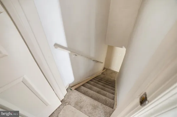 a view of staircase with white walls and railing
