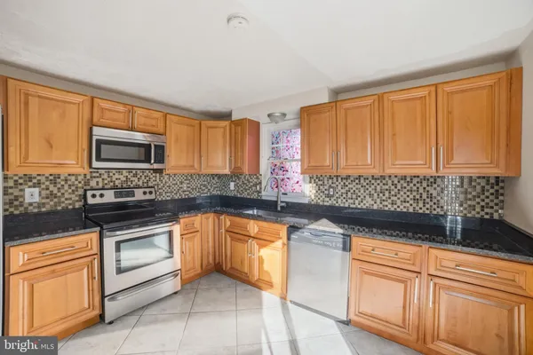 a kitchen with stainless steel appliances granite countertop a sink stove and microwave