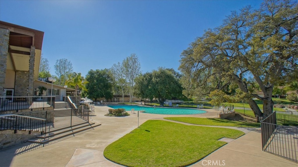19334 Oak Crossing Road Newhall, CA 91321 - Photo 24 of 36 a view of a swimming pool with a bench and trees around