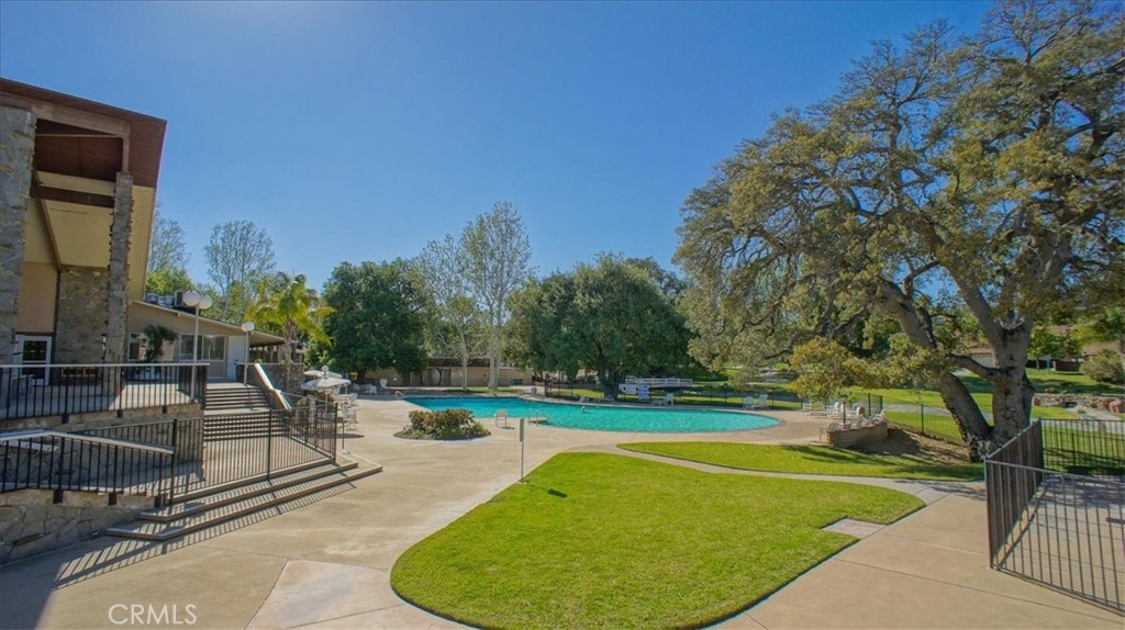 19334 Oak Crossing Road Newhall, CA 91321 - Photo 24 of 36 a view of a swimming pool with a bench and trees around