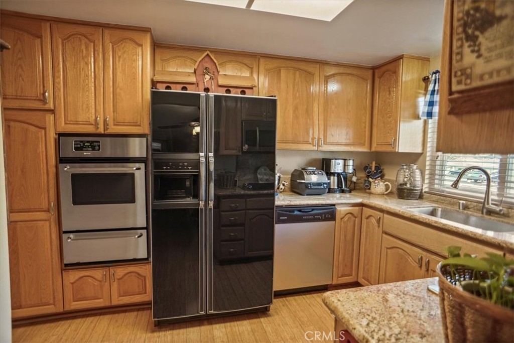 19334 Oak Crossing Road Newhall, CA 91321 - Photo 7 of 36 a kitchen with stainless steel appliances granite countertop a refrigerator and a sink