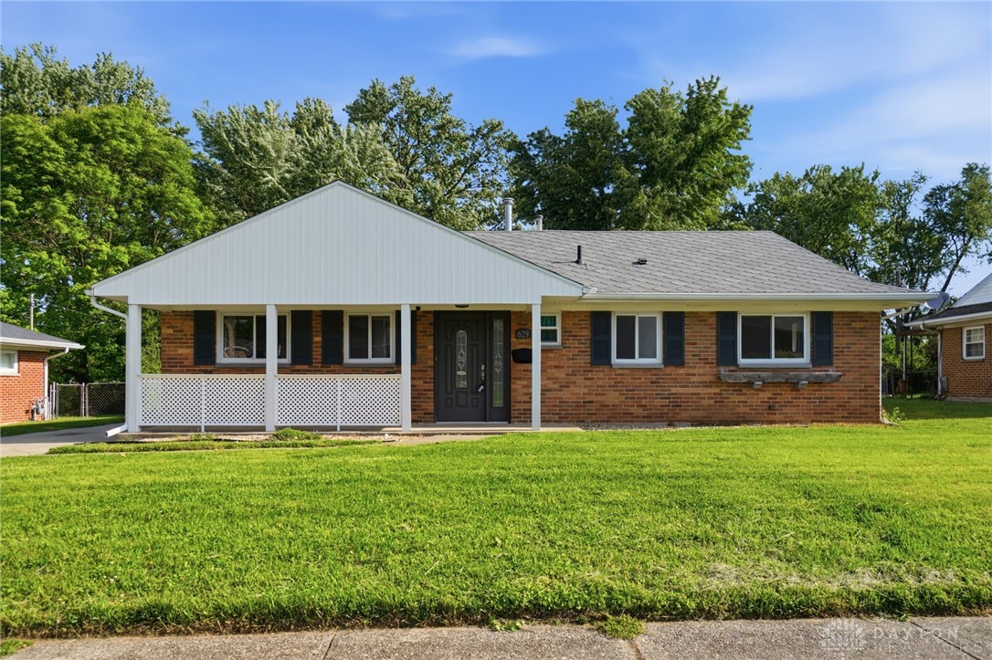 This charming residence features a classic brick exterior and a welcoming covered porch.