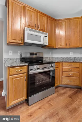 a kitchen with granite countertop wooden cabinets and stainless steel appliances