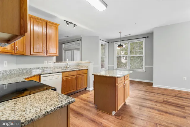 a kitchen with stainless steel appliances granite countertop wooden cabinets a sink and a stove