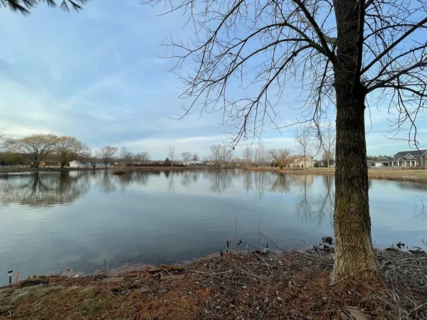 a backyard of a house with lots of green space and lake view