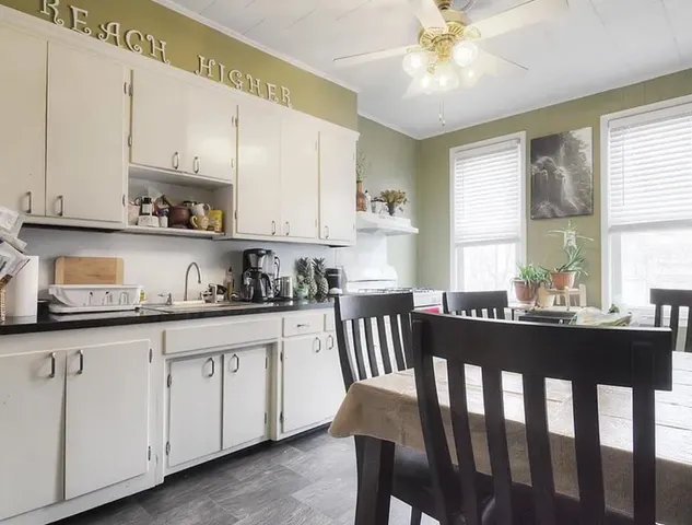 a kitchen with granite countertop white cabinets a sink and dishwasher with wooden floor