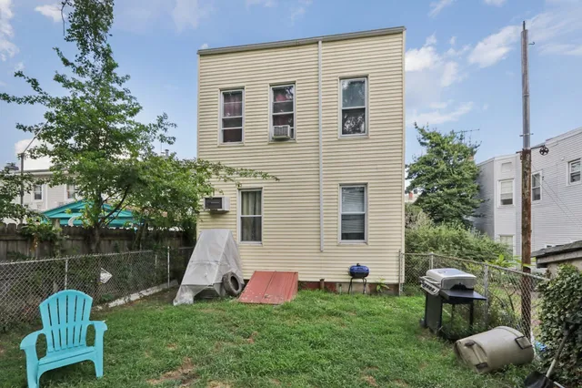 a front view of a house with backyard and garden