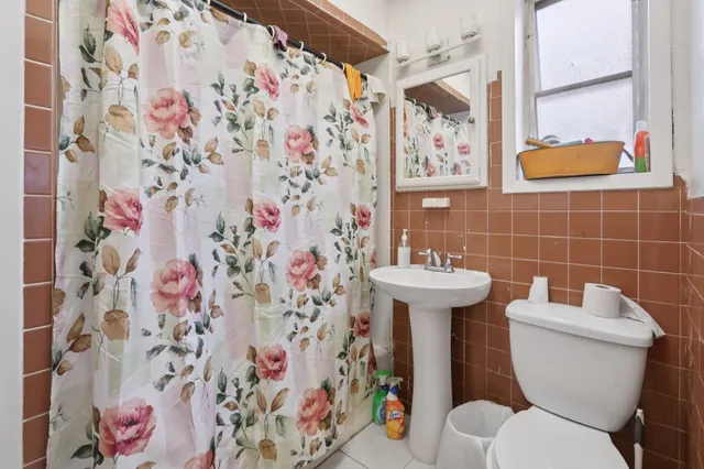 a bathroom with a toilet and a shower curtain