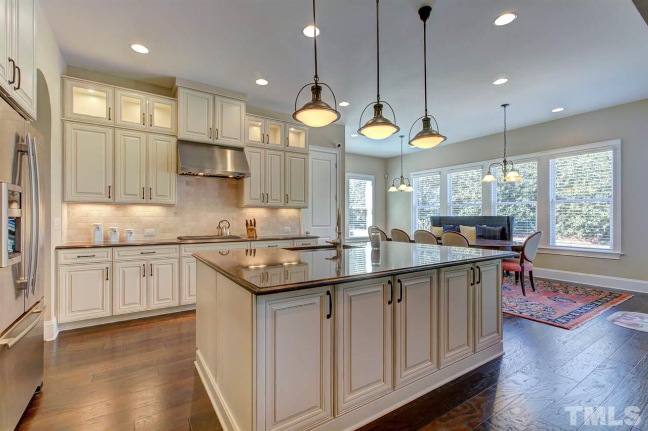 8205 Cranes View Place East Raleigh, NC 27615 - Photo 18 of 30 a kitchen with stainless steel appliances granite countertop a sink a stove and a wooden cabinets