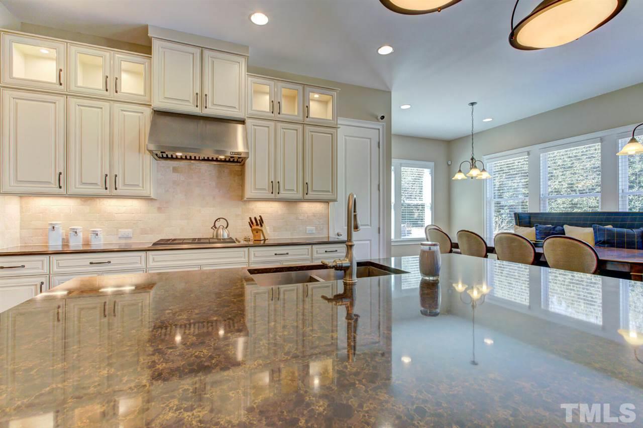 8205 Cranes View Place East Raleigh, NC 27615 - Photo 19 of 30 a kitchen with stainless steel appliances granite countertop a sink a stove counter space and cabinets