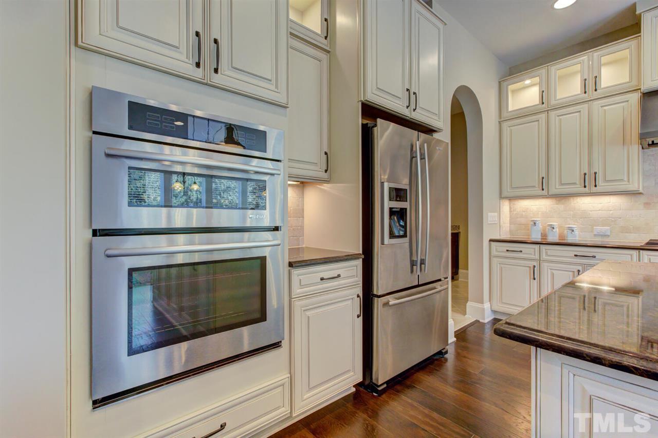 8205 Cranes View Place East Raleigh, NC 27615 - Photo 20 of 30 a kitchen with granite countertop stainless steel appliances and wooden floor