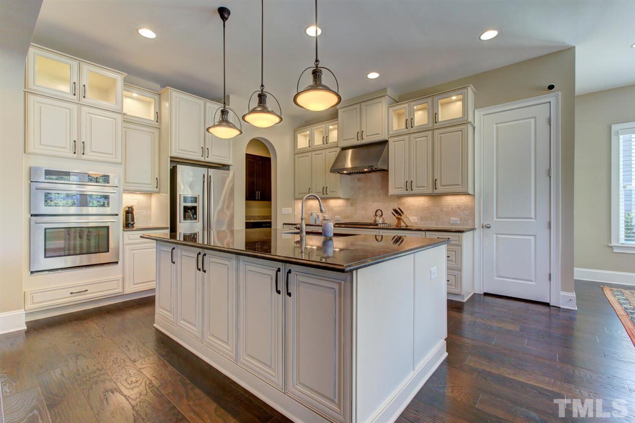 8205 Cranes View Place East Raleigh, NC 27615 - Photo 21 of 30 a large kitchen with stainless steel appliances a large center island attached withe living room