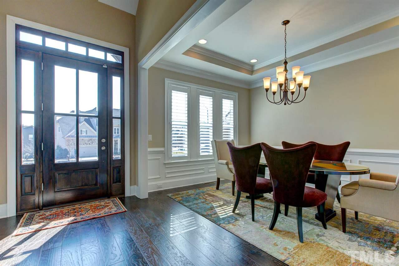 8205 Cranes View Place East Raleigh, NC 27615 - Photo 6 of 30 a view of a dining room with furniture a chandelier and wooden floor