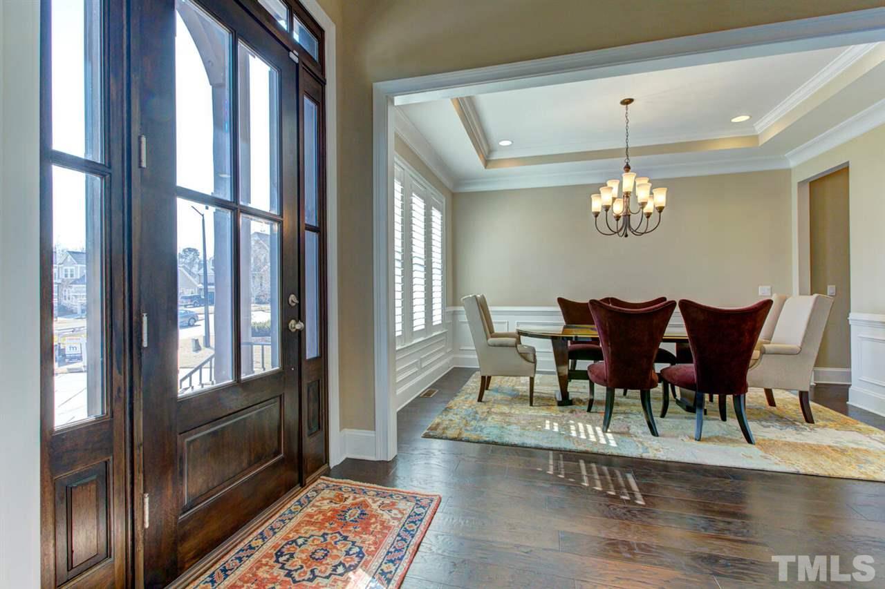 8205 Cranes View Place East Raleigh, NC 27615 - Photo 7 of 30 a view of a dining room with furniture a chandelier and wooden floor