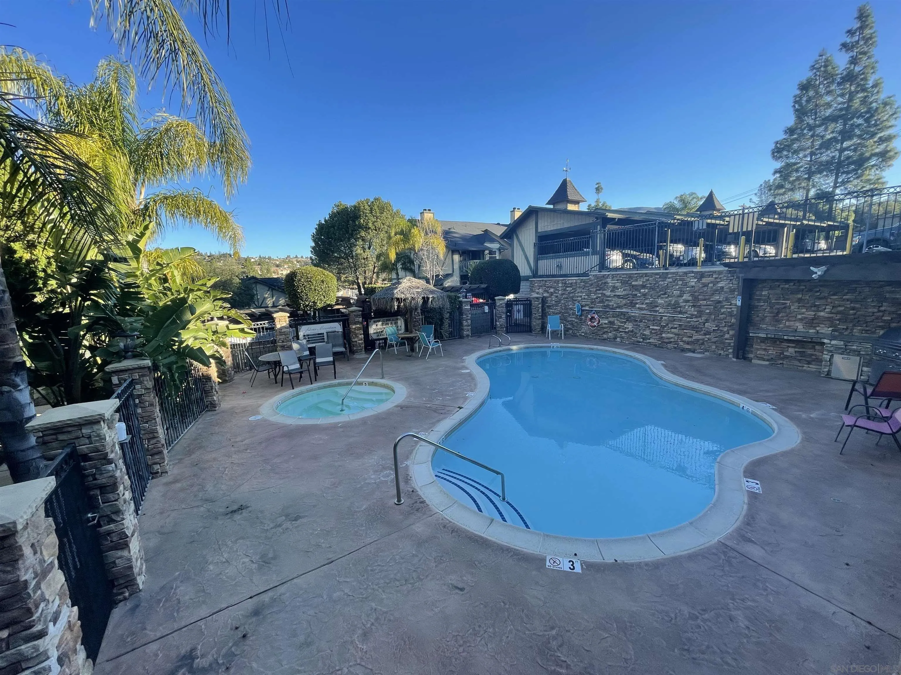 1434 Marshall Road, Unit 56 Alpine, CA 91901 - Photo 11 of 15 a view of a swimming pool with lawn chairs under an umbrella