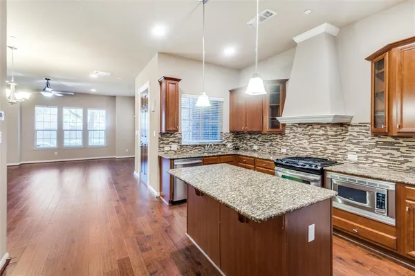 a kitchen with stainless steel appliances granite countertop a sink stove and wooden floor
