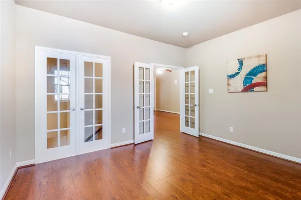 an empty room with wooden floor and window