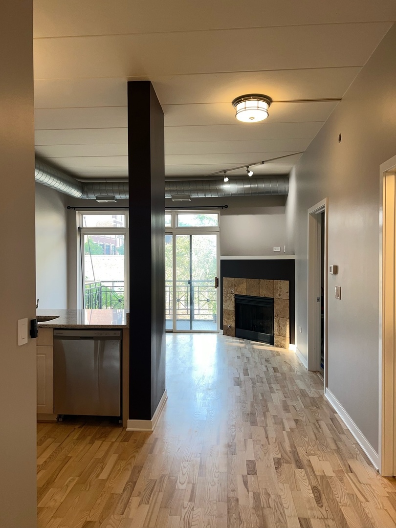 1155 West Madison Street, Unit 305 Chicago, IL 60607 - Photo 6 of 7 a view of an empty room with wooden floor and a window