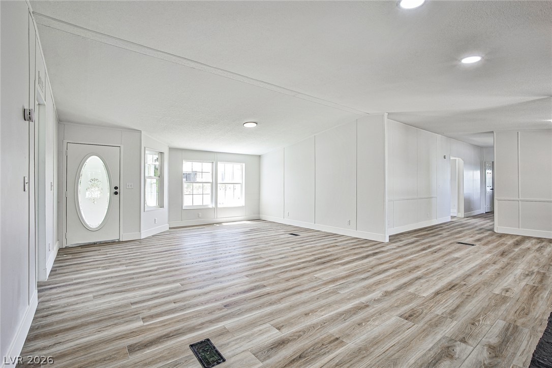 273 Aztec Lane Henderson, NV 89015 - Photo 9 of 28 Natural light floods this generously sized living area, featuring fresh flooring and crisp white walls.