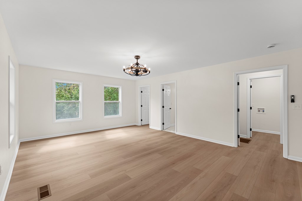 5915 Frazier Drive Columbus, GA 31909 - Photo 12 of 28 an empty room with wooden floor chandelier and windows