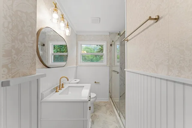 a bathroom with a toilet sink and mirror